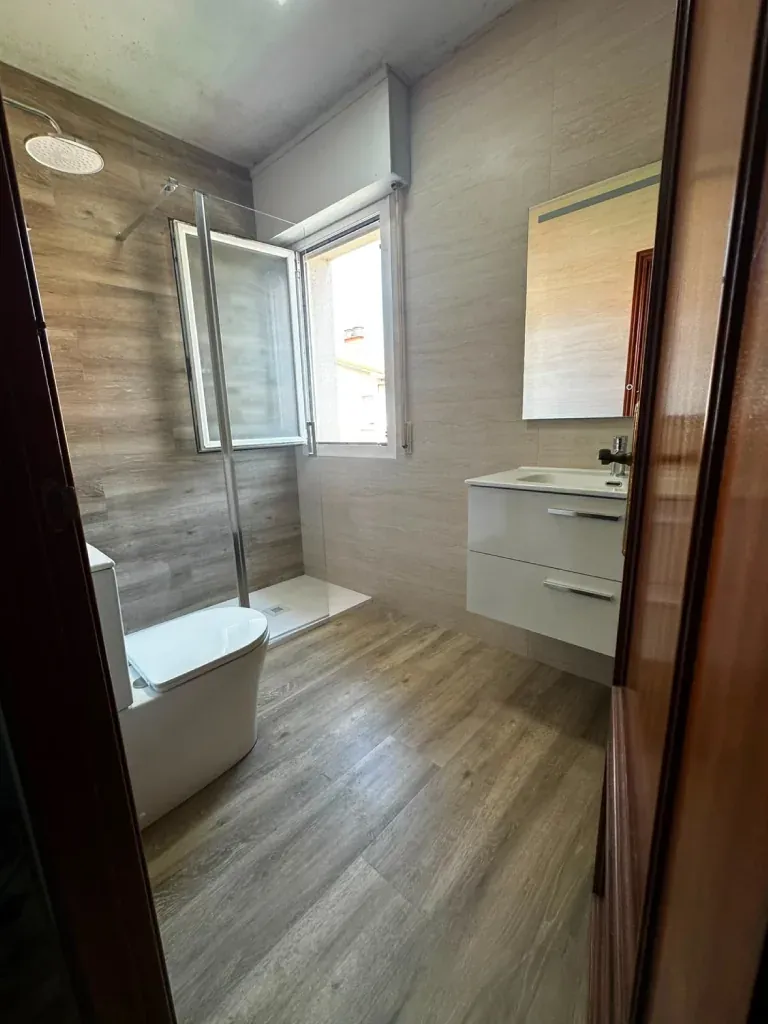 Baño terminado con plato de ducha y mueble de lavabo suspendido
