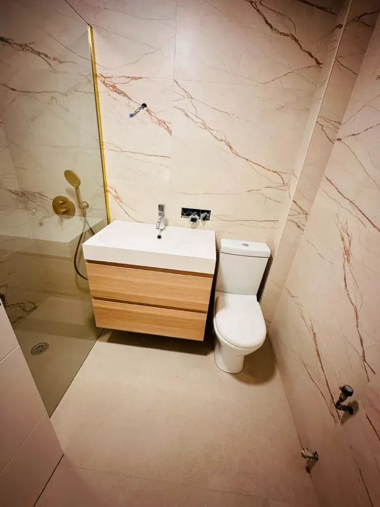 Ducha de obra en mármol con grifería en dorado