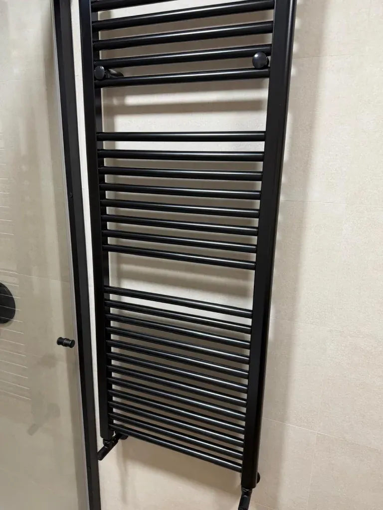Radiador toallero eléctrico colocado en baño reformado