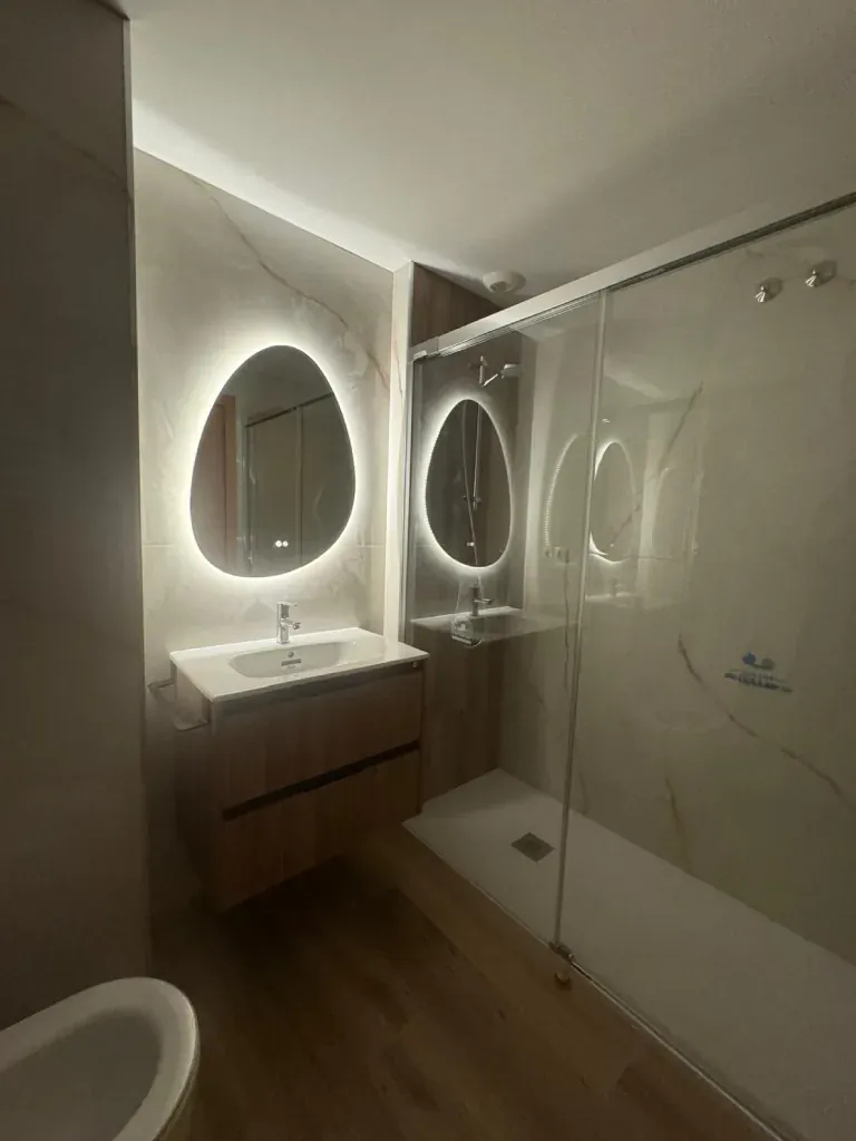 Ducha con mampara y dos espejos redondos con luz