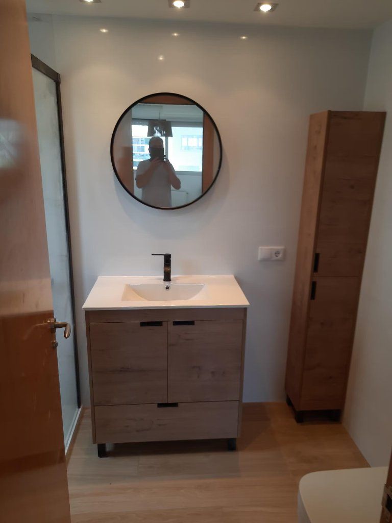 Lavabo con mueble de madera y columna de almacenaje